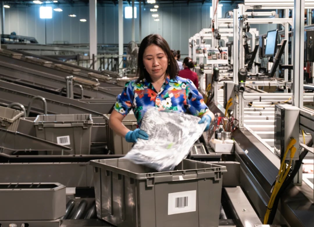 fulfillment warehouse employee packing orders in bin